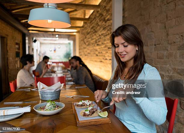 woman eating at a mexican restaurant - mexican restaurant stock pictures, royalty-free photos & images