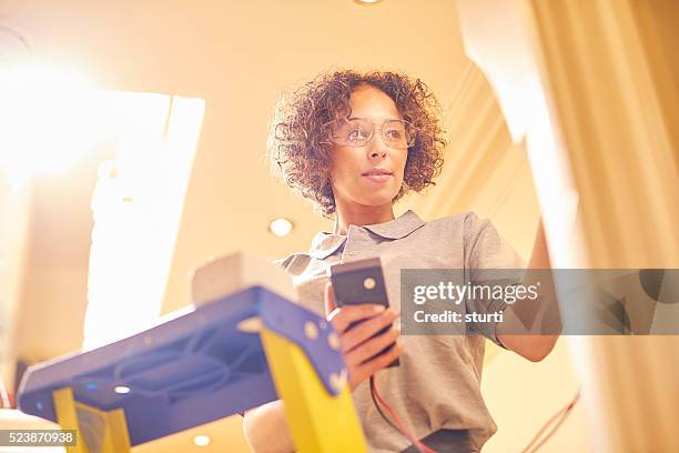 female electrician in home refurb - installing ceiling light fixture stock pictures, royalty-free photos & images