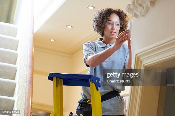 female spark - installing ceiling light fixture stock pictures, royalty-free photos & images