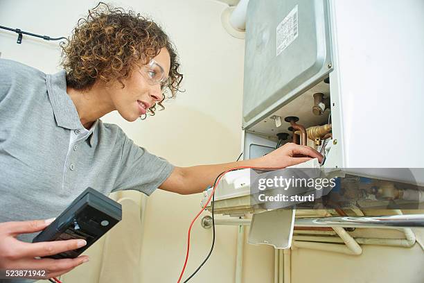 fontanero con calefacción central hembra - instalación para bombilla fotografías e imágenes de stock