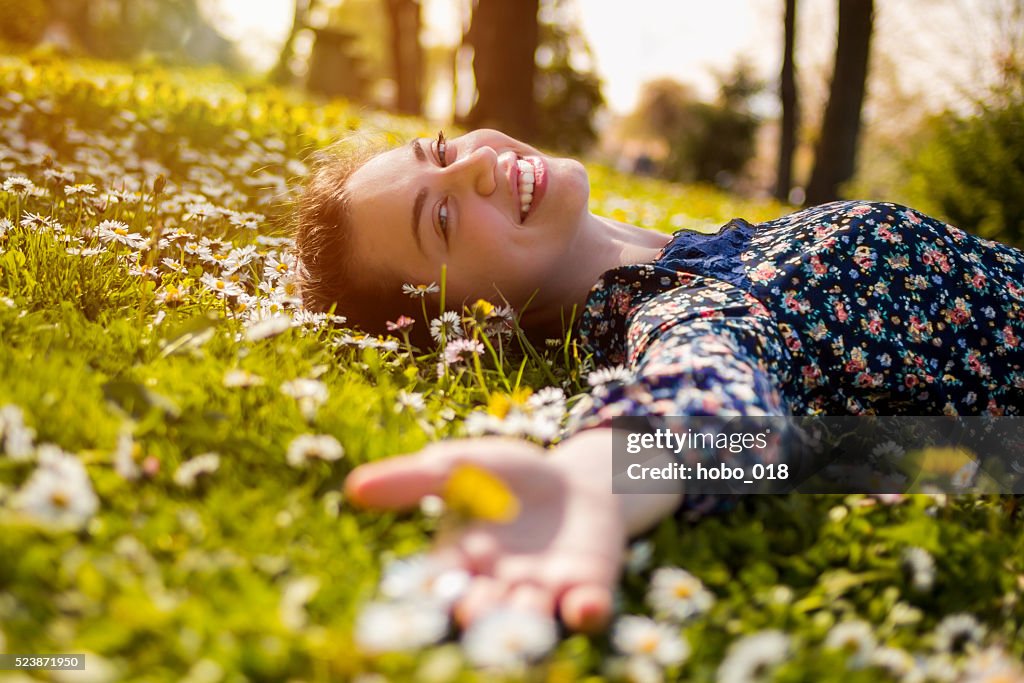 Jolie jeune adolescente se détendre sur une herbe