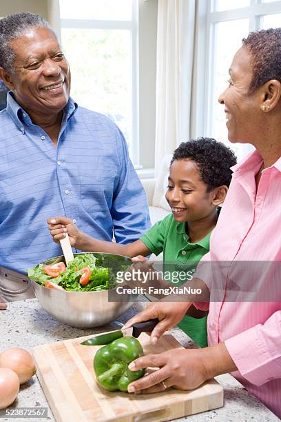 grandparents preparing salad with grandson - groene paprika stockfoto's en -beelden
