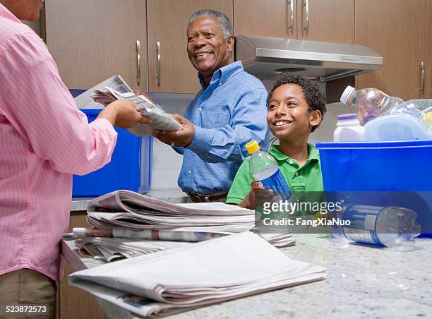grandparents recycling with grandson in kitchen - person of colour stock pictures, royalty-free photos & images