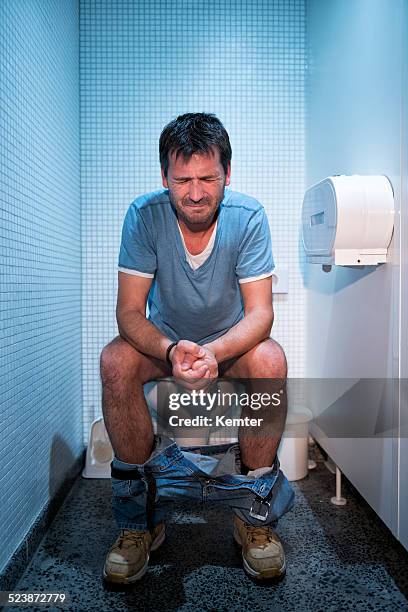 man sitting in public restroom - toilet bildbanksfoton och bilder