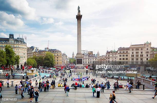 busy trafalgar square london uk on sunny autumn afternoon - trafalgar square stockfoto's en -beelden