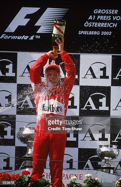 Race runner-up Ferrari driver Rubens Barrichello of Brazil pours champagne over himself on the podium after the Austrian Formula One Grand Prix held...