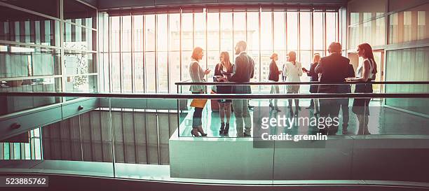 grupo de gente de negocios en el lobby del edificio de oficinas - panoramica horizontal fotografías e imágenes de stock