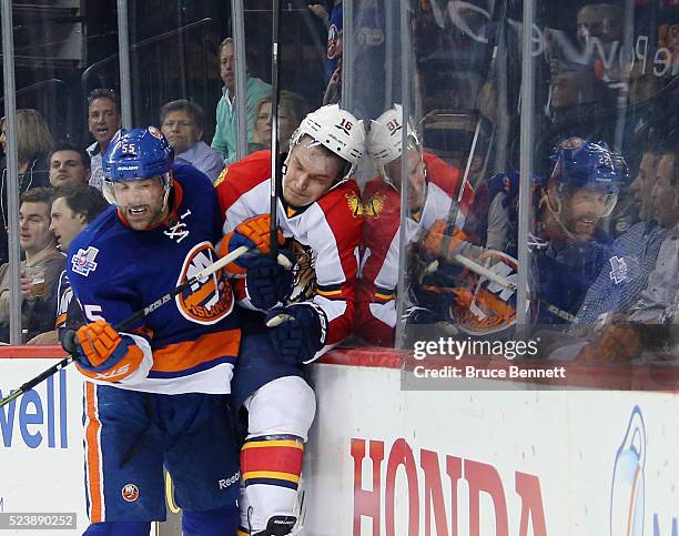 Aleksander Barkov of the Florida Panthers is checked into the boards by Johnny Boychuk of the New York Islanders during the first period in Game Six...