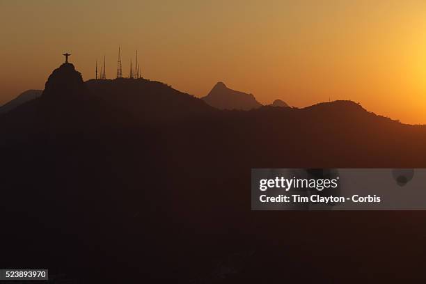 The iconic Cristo Redentor, Christ the Redeemer statue at sunset atop the mountain Corcovado shot from Sugar Loaf Mountain. The Christ statue was...