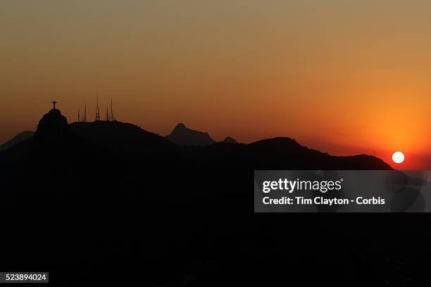 The iconic Cristo Redentor, Christ the Redeemer statue at sunset atop the mountain Corcovado shot from Sugar Loaf Mountain. The Christ statue was...