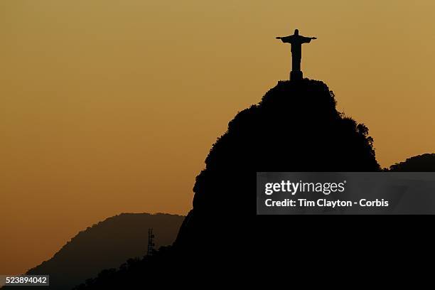 The iconic Cristo Redentor, Christ the Redeemer statue at sunset atop the mountain Corcovado shot from Sugar Loaf Mountain. The Christ statue was...