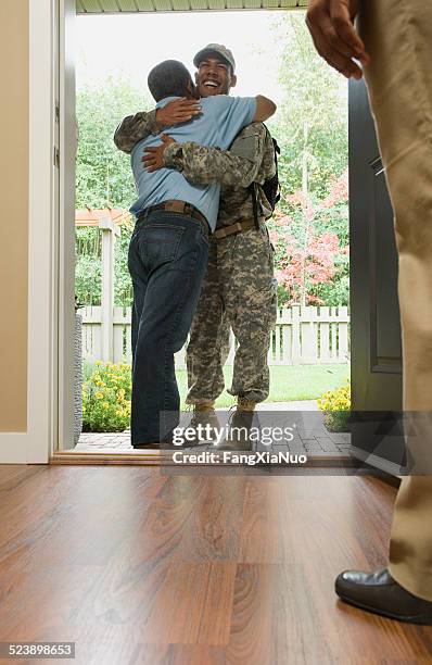 father hugging returning soldier - returning soldier stock pictures, royalty-free photos & images