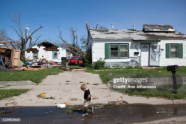 Alex Collette plays in the water near his home in the Oaklawn area of Wichita that was struck by a tornado, April 15, 2012.