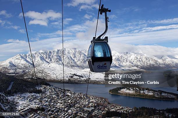 View of Queenstown, New Zealand with the Skyline Gondola and the snow covered Remarkables mountain range providing a stunning backdrop after winter...