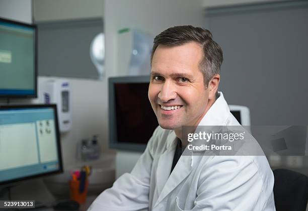 happy male optometrist in clinic - one mature man only stock pictures, royalty-free photos & images