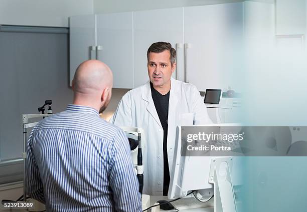 optometrist discussing with patient - eye doctor and patient stock pictures, royalty-free photos & images