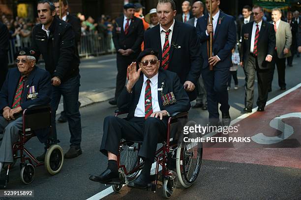 War veteran waves to the crowds during the ANZAC parade to mark the centenary of the Gallipoli landings in Sydney on April 25, 2016 Thousands...