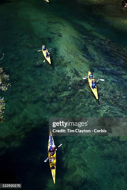 Kayakers venture down crystal clear waters of a sheltered lagoon in the Abel Tasman National Park., South Island, New Zealand, The Abel Tasman...