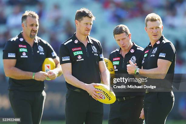 Magpies head coach Nathan Buckley looks upfield with his assistants during the round five AFL match between the Collingwood Magpies and the Essendon...