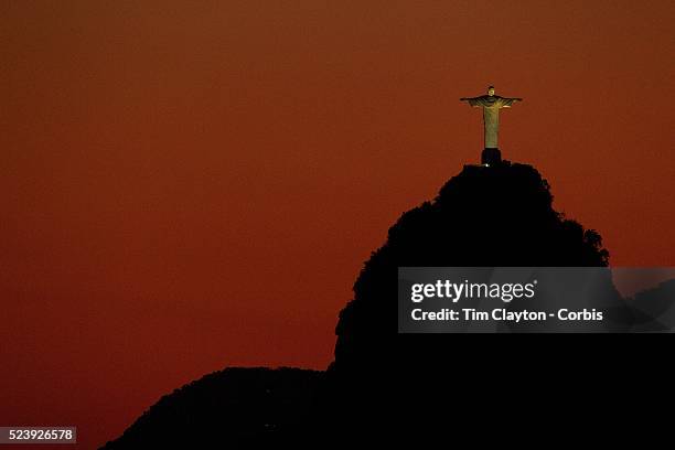 The iconic Cristo Redentor, Christ the Redeemer statue at sunset atop the mountain Corcovado shot from Sugar Loaf Mountain. The Christ statue was...