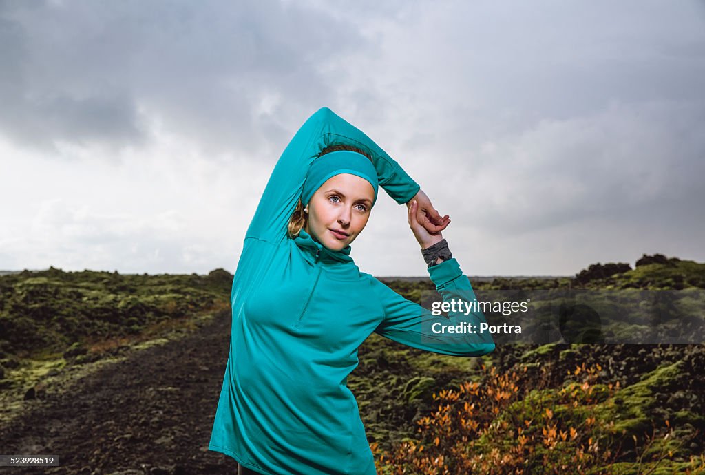 Determined woman exercising on arid landscape