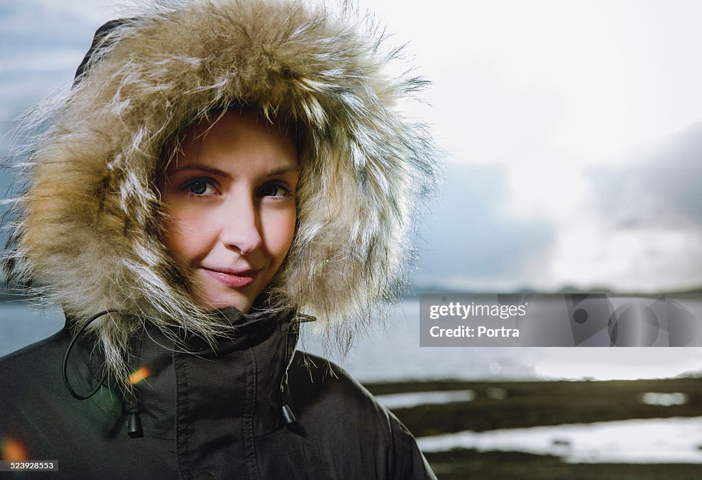 Smiling woman wearing fur hood during winter