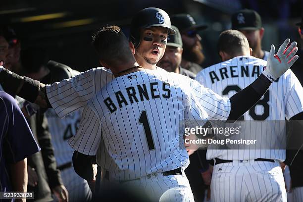 Carlos Gonzalez of the Colorado Rockies celebrates with Brandon Barnes after scoring against the Los Angeles Dodgers at Coors Field on April 24, 2016...