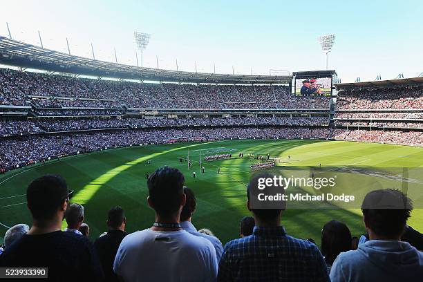 The players and crowd stand for a minutes silence in tribute to Anzac Day during the round five AFL match between the Collingwood Magpies and the...