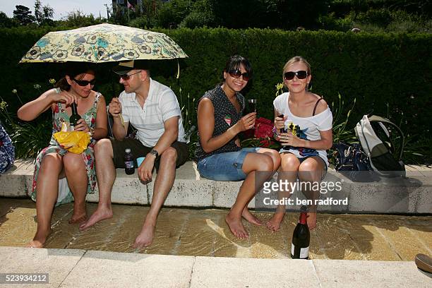 Tennis fans cool down in the stream as they watch the scoreboard on Henman Hill during Day 8 of the 2009 Wimbledon Tennis Championships at the All...