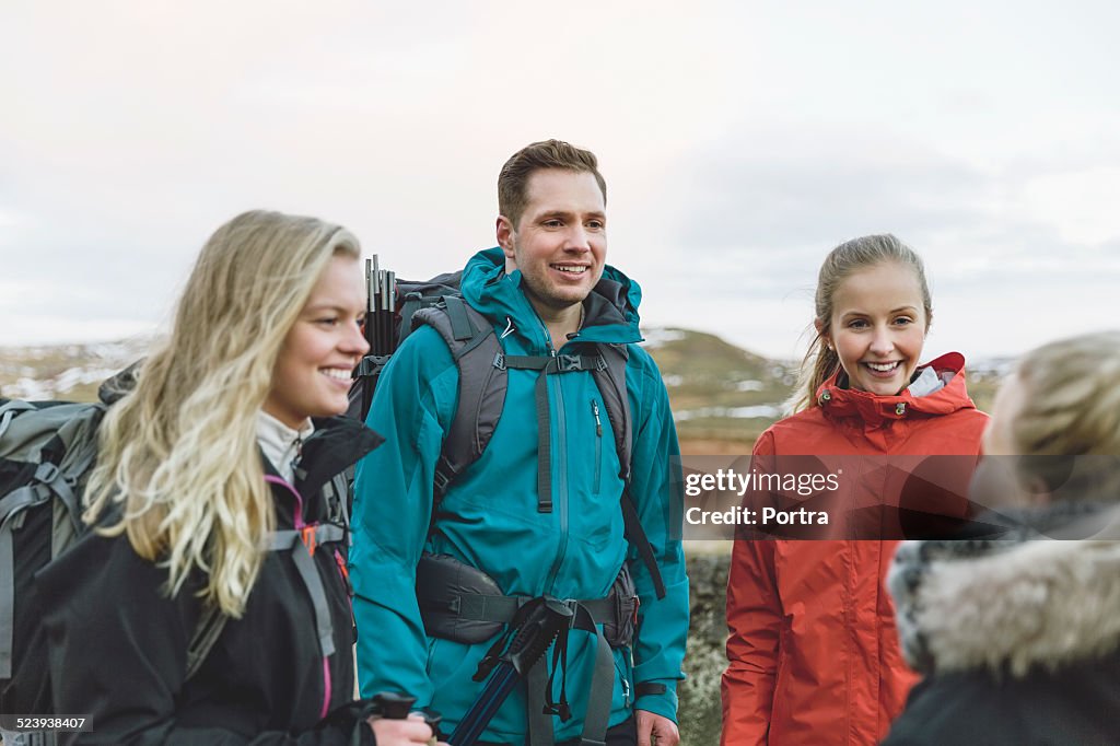 Happy hikers talking against sky