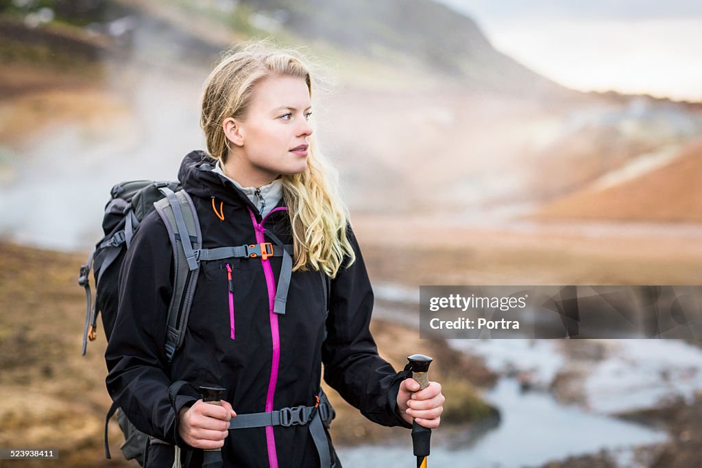 Hiker carrying backpack on volcanic landscape