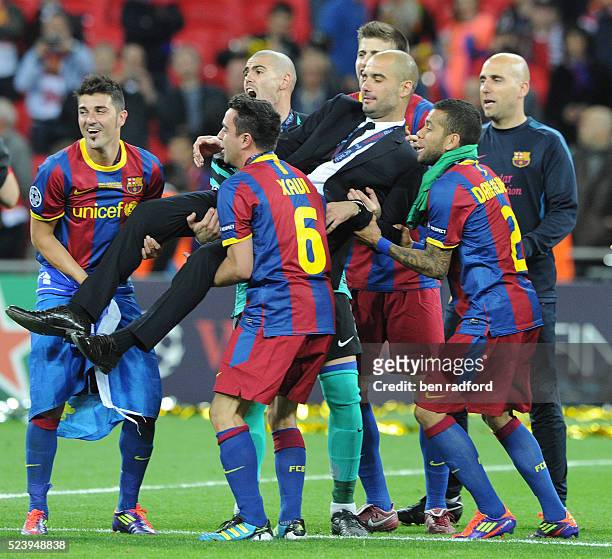 David Villa, Xavi Hernandez, Danny Alves and Victor Valdes of Barcelona lift Coach Pep Guardiola in celebration after the 2011 UEFA Champions League...