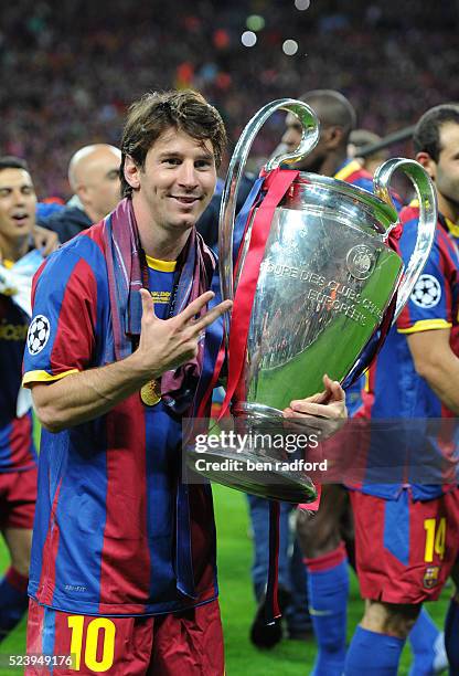Lionel Messi of Barcelona holds the European Cup in victory and shows three fingers, one for each Champions League win after the 2011 UEFA Champions...