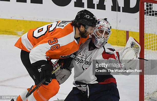 Washington Capitals goalie Braden Holtby gloves the puck as Philadelphia Flyers right wing Colin McDonald skates into him during the first period of...