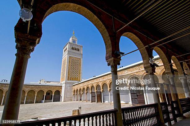 Gallery and colonnade of the inner courtyard of the big mosque Jamaa Ez Zitouna with minaret in the medina of Tunis