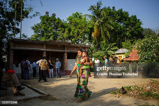 Betal Para, Bangladesh A woman with a child on her arm walks along a farm in a rural area in the southwest of Bangladesh on April 10, 2016 in Betal...