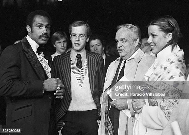 Prince Rainier of Monaco, accompanied by son Prince Albert and daughter Princess Caroline, chat with heavyweight boxer Ken Norton at the Louis II...