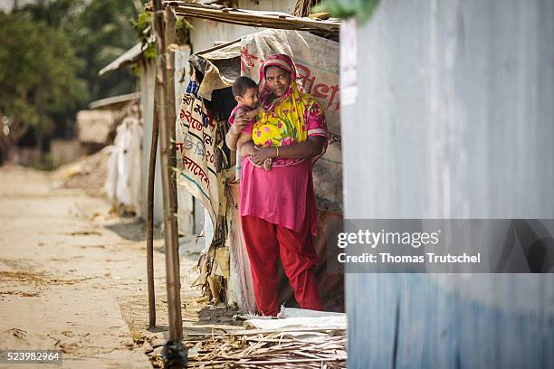 Khulna, Bangladesh A woman with a small child on her arms standing at the entrance of her hut on April 11, 2016 in Khulna, Bangladesh.