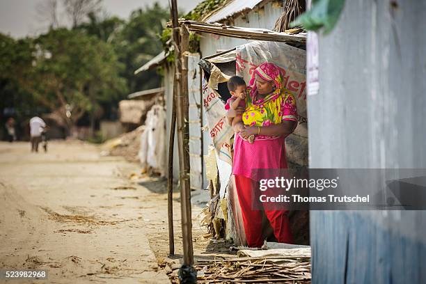 Khulna, Bangladesh A woman with a small child on her arms standing at the entrance of her hut on April 11, 2016 in Khulna, Bangladesh.