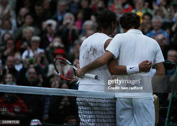 Champion Rafael Nadal and beaten former Champion Roger Federer each place an arm around the other after Nadal wins the Men's Singles Final on Day 13...