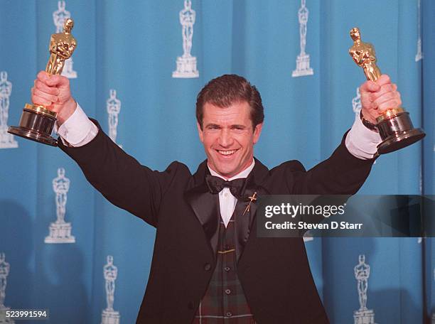 Mel Gibson holds his dual Oscars at the 1996 Academy Awards ceremony in Los Angeles. Gibson won the award for Best Director for his film Braveheart,...