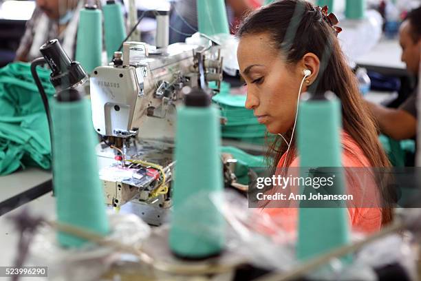 An unidentified woman sews clothing at the American Apparel factory, downtown Los Angeles, November 6, 2013.