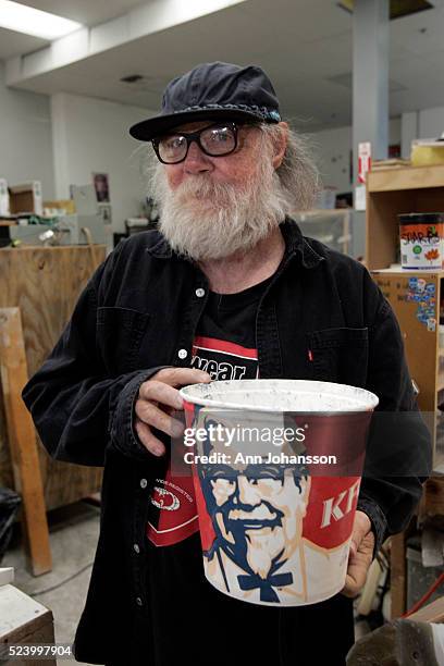 Artist Paul McCarthy plays around posing with a Kentucky Fried Chicken bucket in his studio in the Baldwin Park area of Los Angeles, April 14, 2010.