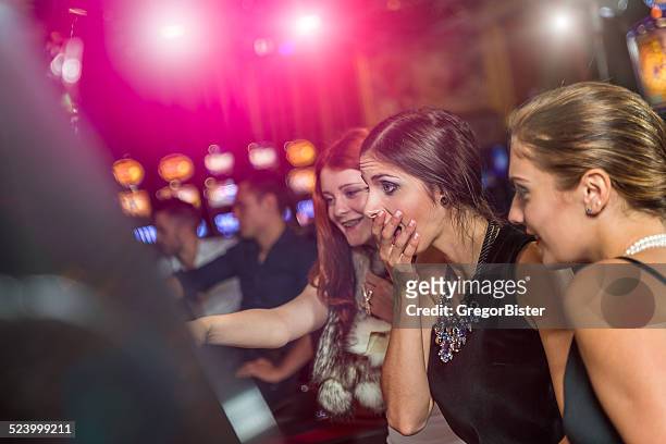 woman in a casino winning at slot machine - teen pokies stock pictures, royalty-free photos & images