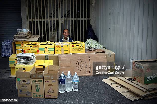 Shinpei Kirita, who has lived homeless in Kamagasaki for ten years, poses for a photograph behind the boxes he has piled up around his bed in the...