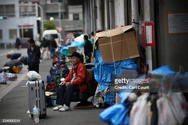 Homeless men wait in the street for the offer of work in the slum area of Kamagasaki on April 23, 2016 in Osaka, Japan. Kamagasaki, a district in...