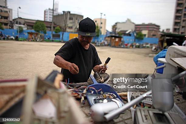 Man dismantles a television to sell the parts, in the slum area of Kamagasaki on April 23, 2016 in Osaka, Japan. Kamagasaki, a district in Japan's...