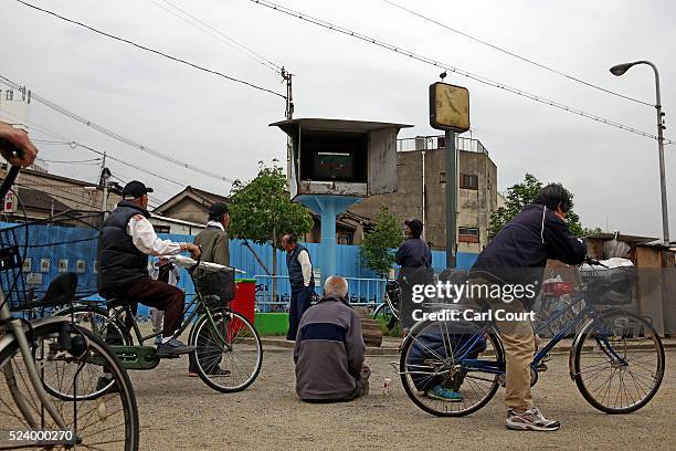 Men watch a television supplied by the local government in the slum area of Kamagasaki on April 24, 2016 in Osaka, Japan. Kamagasaki, a district in...