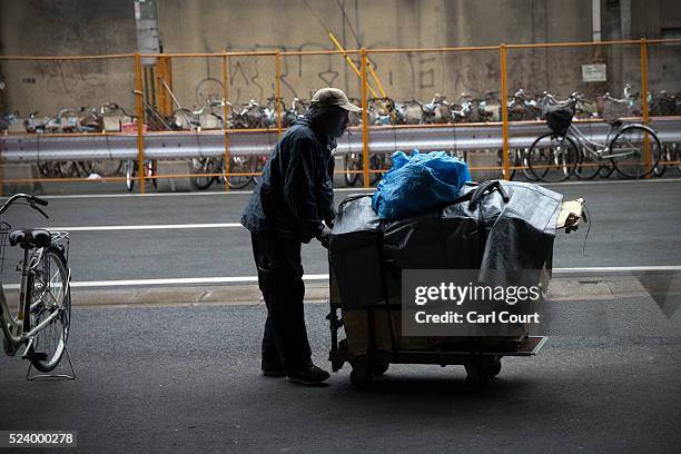 Homeless man pushes a cart with his belongings in the slum area of Kamagasaki on April 23, 2016 in Osaka, Japan. Kamagasaki, a district in Japan's...