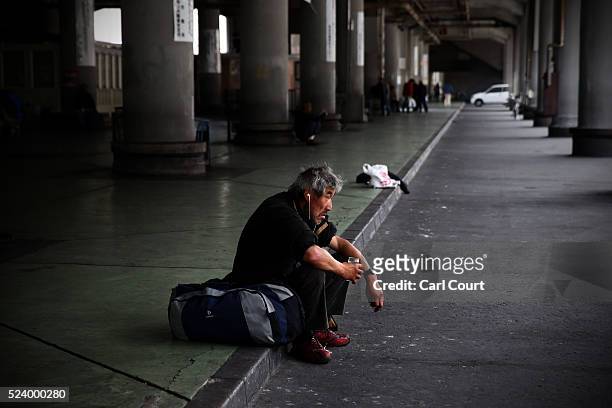 Man sits on the ground in the slum area of Kamagasaki on April 23, 2016 in Osaka, Japan. Kamagasaki, a district in Japan's second largest city Osaka,...